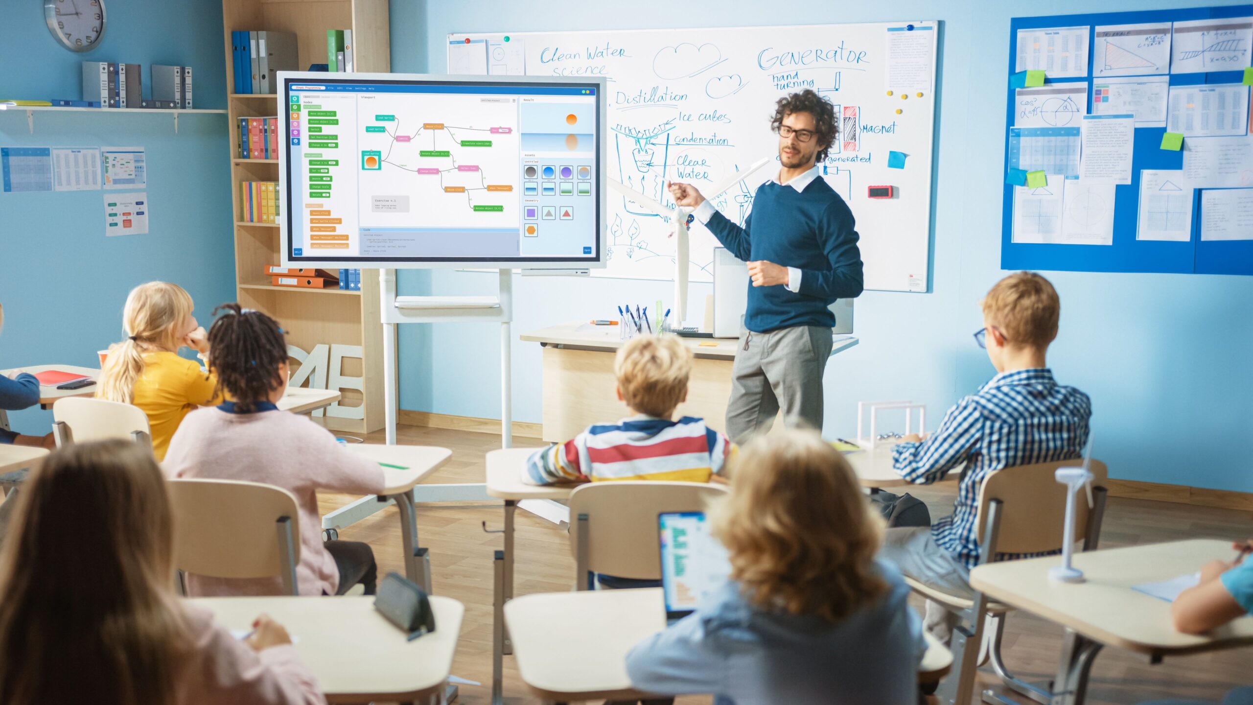 Elementary School Computer Science Teacher Uses Interactive Digital Whiteboard to Show Programming Logics to a Classroom