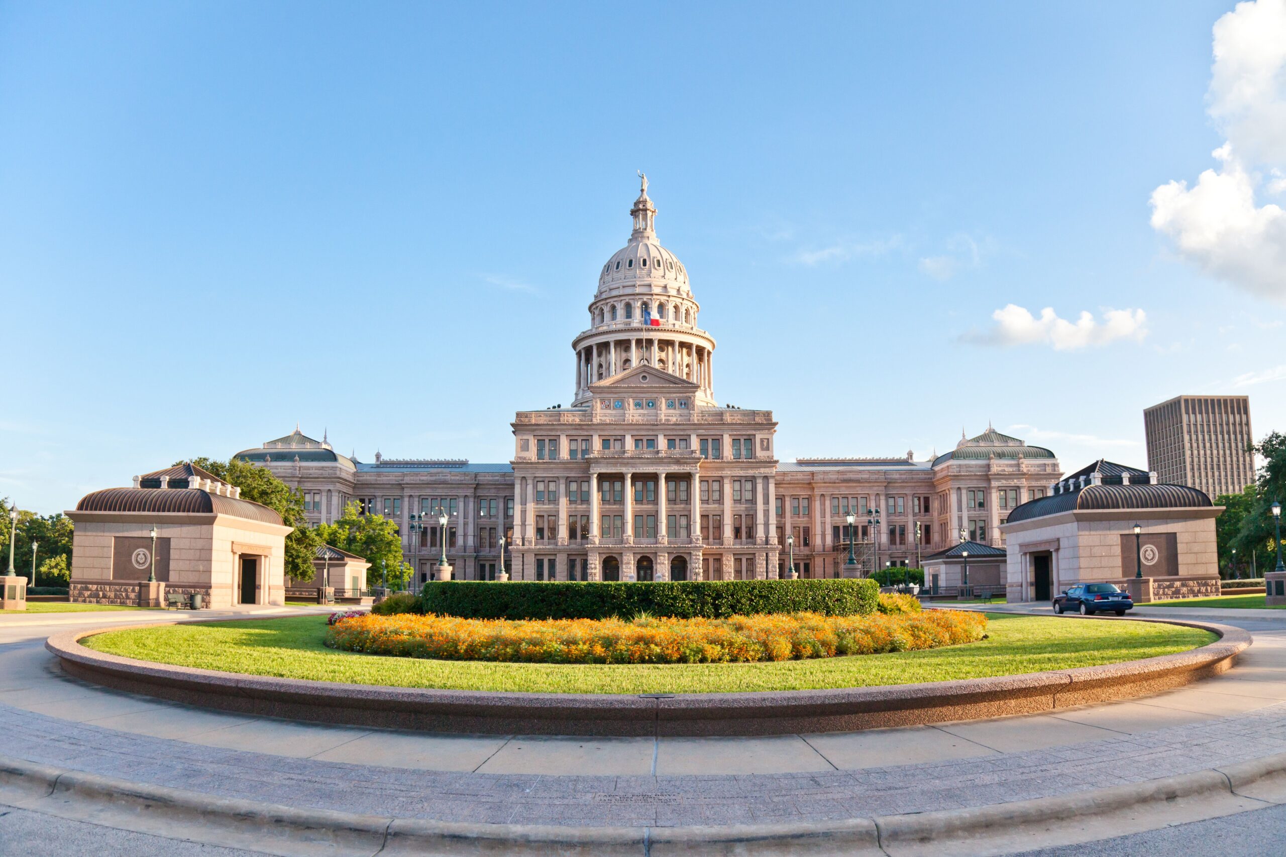The United States Capitol building, a neoclassical structure, features a large dome and is surrounded by green lawns and trees.