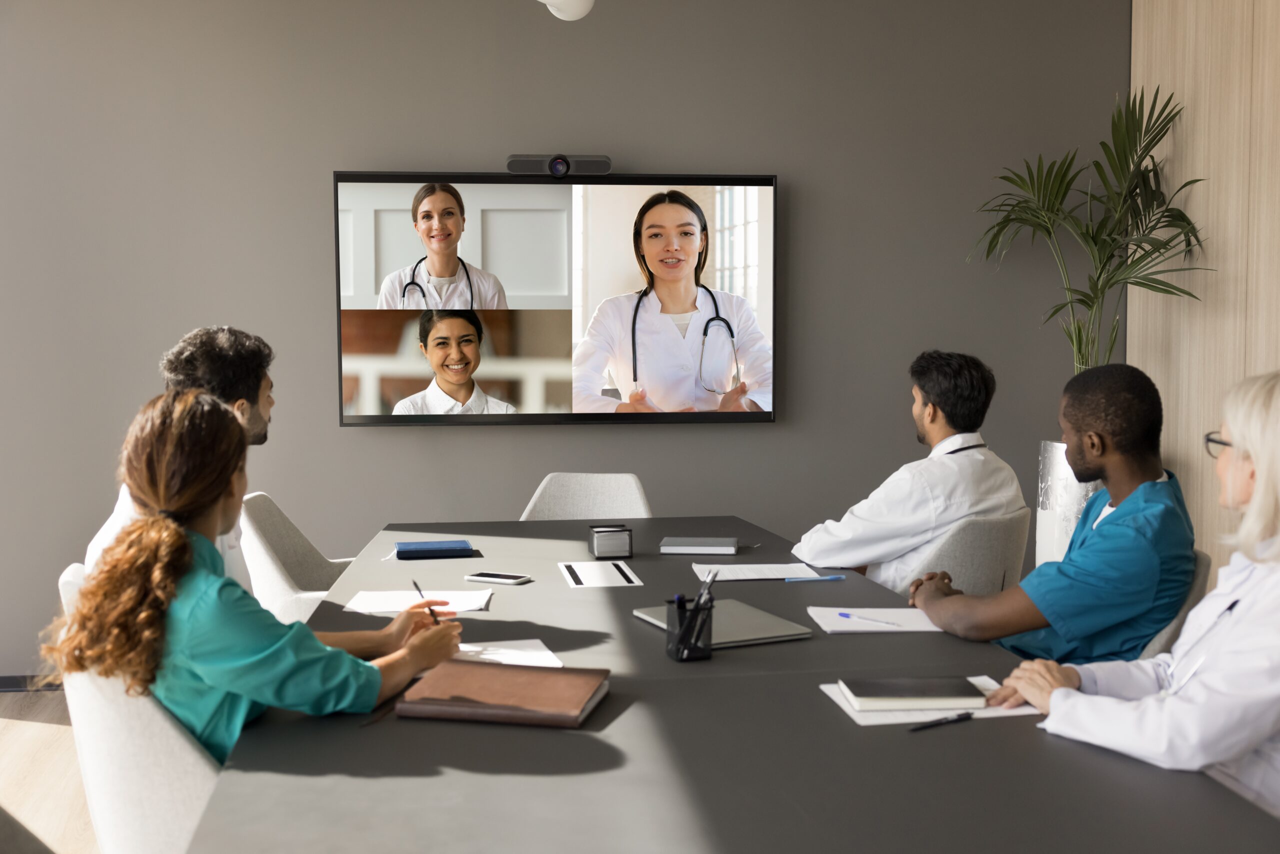 A group of doctors attentively watching a video presentation in a conference room.